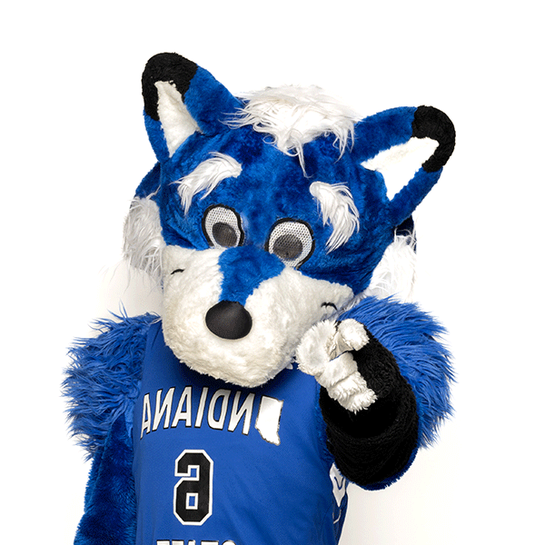 Sycamore Sam, a blue forest woodland creature with a white muzzle, blue and white ears with black tips, white hands, and wearing a blue No. 6 basketball jersey that says Indiana State, points at the camera. Sam is pictured against a white background.